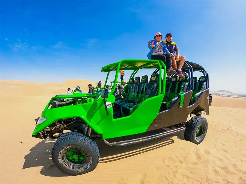 Turistas en buggy sobre las dunas de Huacachina durante el Full Day Paracas Ica Huacachina Año Nuevo desde Lima