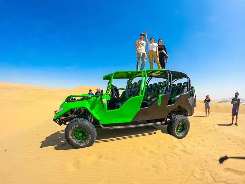 Turistas sobre un tubular en las dunas de Huacachina durante el Full Day Paracas Ica Huacachina desde Lima por Semana Santa