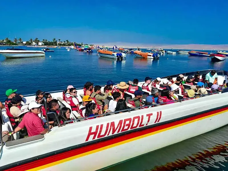 Lancha turística con pasajeros saliendo hacia Islas Ballestas durante el Tour 2 dias Paracas Ica con Hotel en Paracas desde Lima