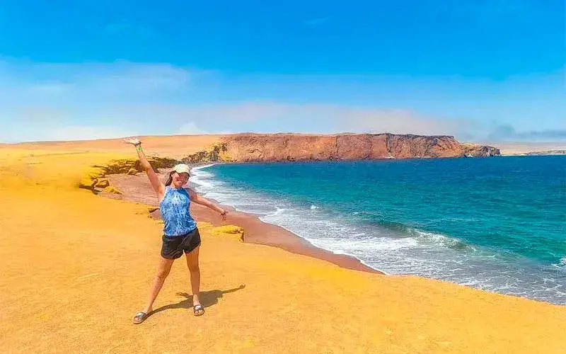 Turista en la Reserva Nacional de Paracas con vista al mar y los paisajes costeros de Playa Roja