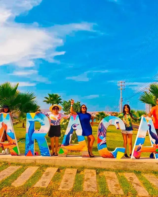 Turistas junto a las letras de Paracas durante el Full Day Paracas Islas Ballestas y Playa la Mina desde Lima