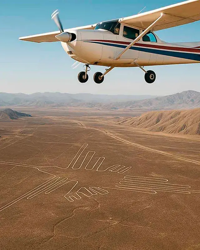 Toma aérea de un sobrevuelo Líneas de Nazca, mostrando la avioneta matrícula B-109 volando sobre el gran geoglifo del Colibrí en el desierto rojo.