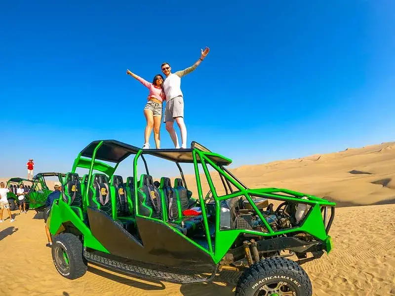 Pareja de turistas sobre buggy en las dunas de Huacachina durante el Tour Ica Huacachina Paracas 2 dias y 1 noche desde Lima