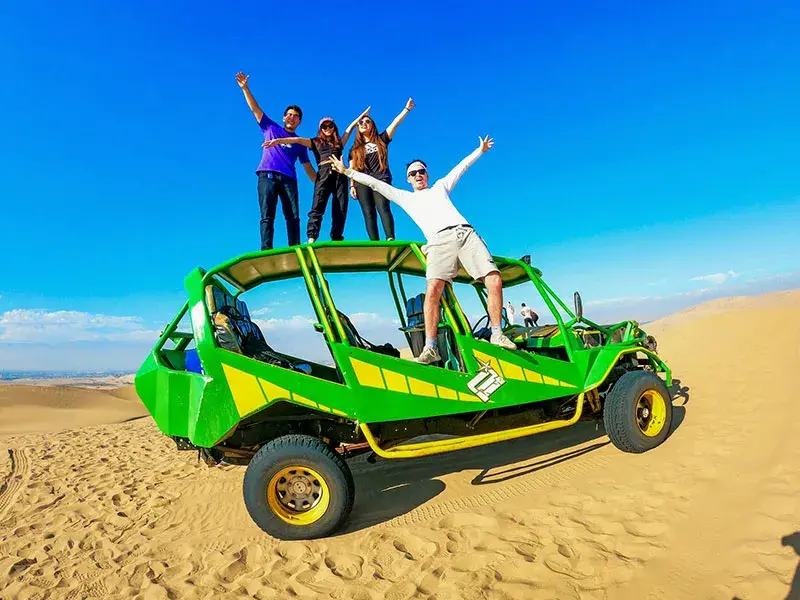 Turistas en buggy sobre las dunas de Huacachina durante el Tour Paracas Ica Huacachina full day con recojo de hotel desde Lima