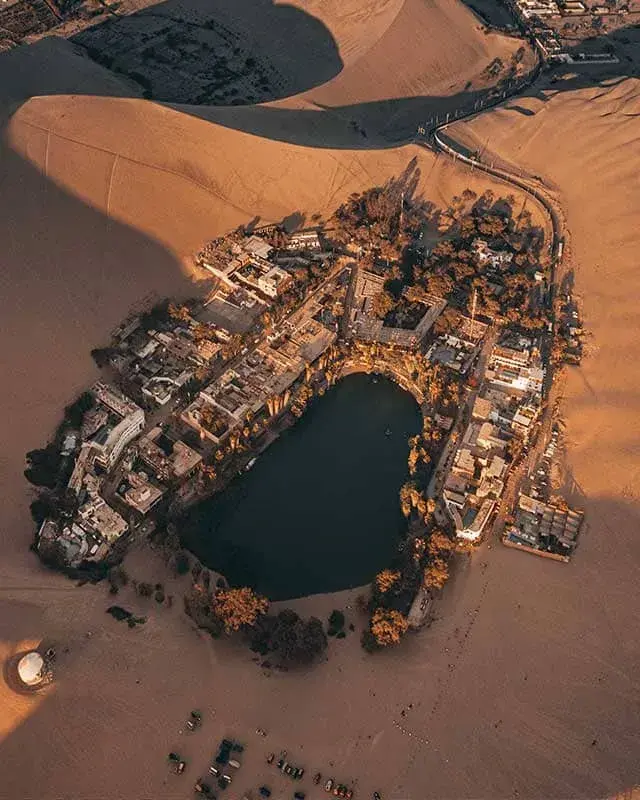 Vista aérea del Oasis de Huacachina rodeado de dunas durante el tour full day con sunset